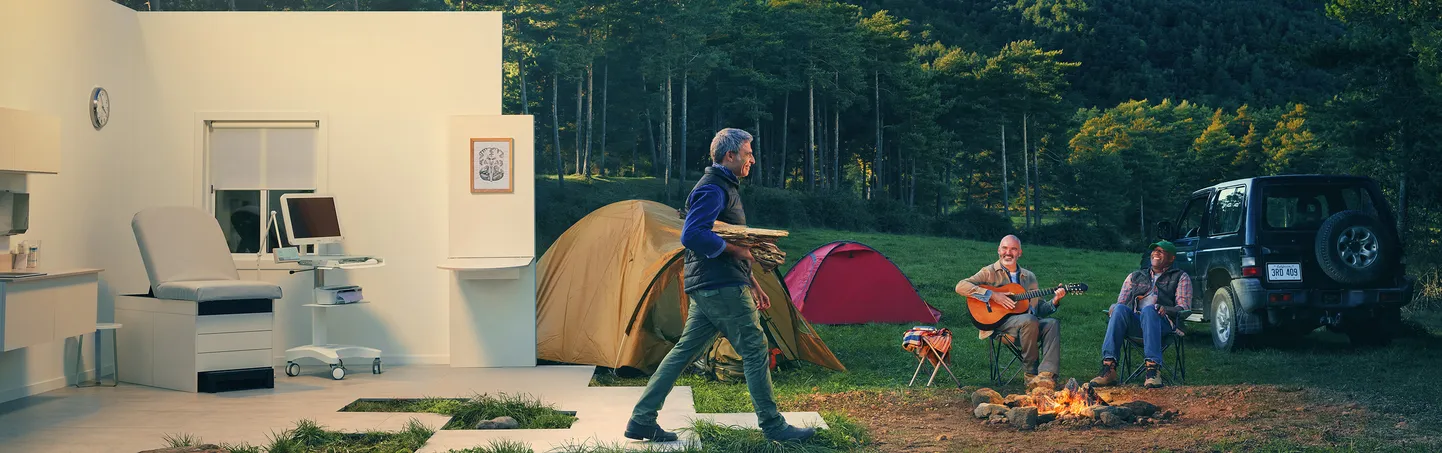 Actor portrayals of a man carrying firewood in a doctor's office that abruptly turns into a campsite with his friends